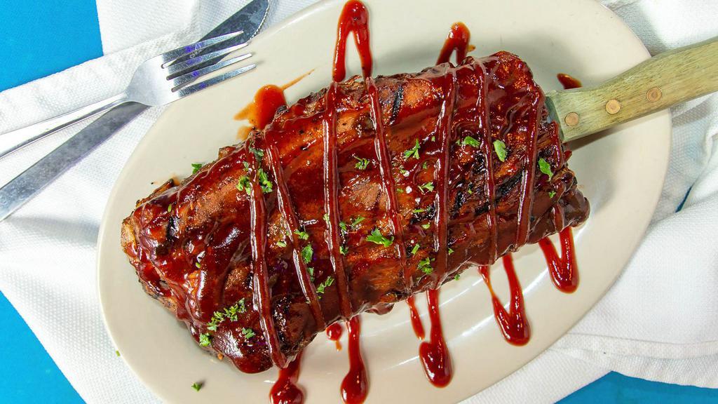 Slab Ribs · Smoked four hours to perfection, drenched in BBQ sauce. Served with French fries and a salad.