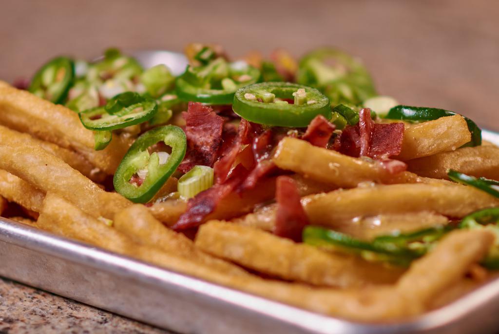Loaded Fries · Fries topped with our house queso cheese, turkey bacon bits, jalapeños and green onion.
