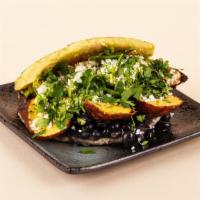 Black Bean Avocado Veggie Arepa · Plantains with crumbled cotija cheese, avocado mash, pinto beans, and cilantro between two w...