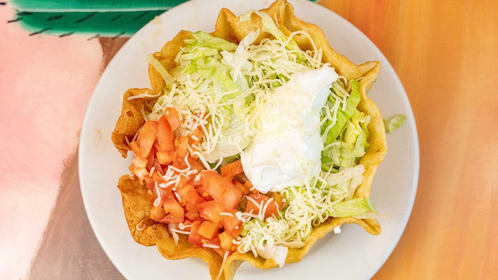 Fajita Taco Salad · Flour tortilla shell filled with pieces of Chicken or beef, lettuce, tomatoes, grated cheese, and sour cream.