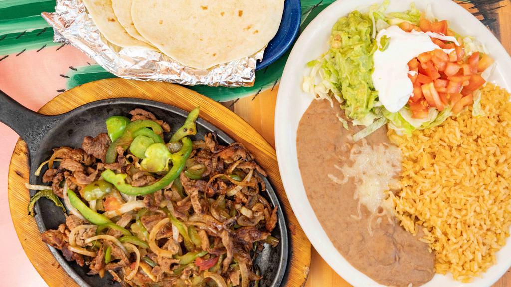 Beef Or Chicken Fajitas · Strips if beef or chicken cooked with tomatoes, onions, bell peppers, served with rice, beans, flour tortillas and guacamole salad.