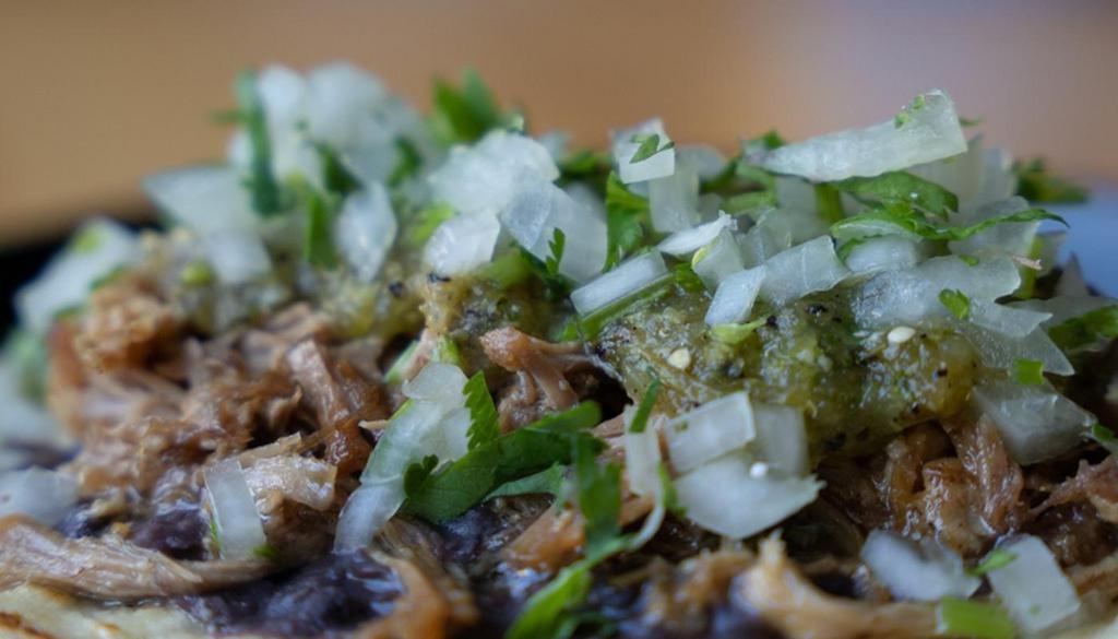 Carnitas Taco · Slowly braised shredded pork, black beans, salsa verde, onion, cilantro.  Gluten Free.