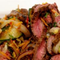 Yum Nuea (Beef Salad) · Thai style sliced grilled beef mixed with onions, tomatoes, cucumbers, celery, and chili-lim...