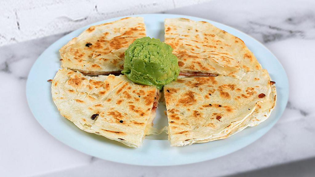 Sincronizadas · Small flour tortilla lightly grilled with ham and cheese served with salsa and avocado.