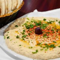 Hummus · Puree of chickpeas, tahini, garlic and lemon juice, topped with olive oil, served with pita ...