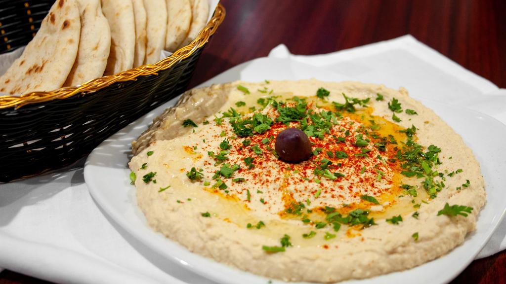 Hummus · Puree of chickpeas, tahini, garlic and lemon juice, topped with olive oil, served with pita bread.