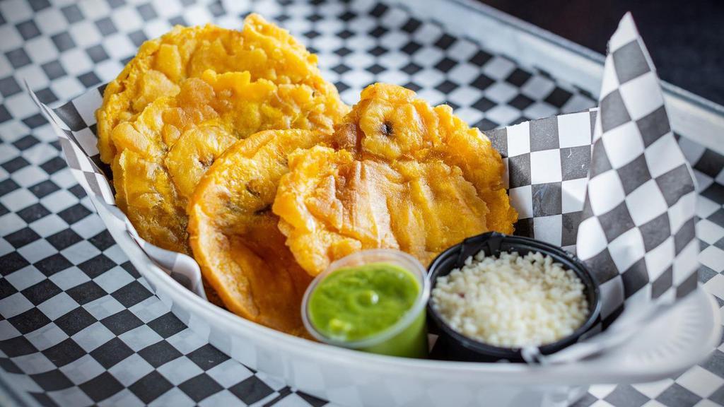 Tostones · Plantain Chips served w/ Salsa Verde & Cotija Cheese