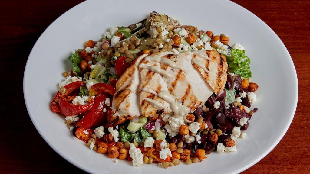 Mediterranean Chicken Salad · Grilled chicken breast julienned and set on a bed of mixed greens tossed in a lemon tahini dressing with harissa chickpeas, lentils, grilled artichoke, fire roasted tomatoes, kalamata olives, cucumber, red onion, and feta cheese.
