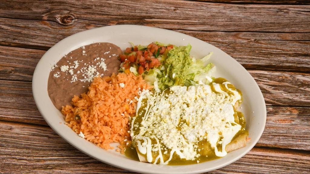 Enchiladas Verdes · Three enchiladas covered in green salsa and stuffed with chicken topped with lettuce, cheese, sour cream, tomatoes, and onions.