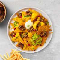 Loaded Nachos · Salted tortilla chips doused in chili, cheese, seasoned ground beef, black olives, tomato, o...