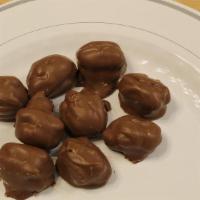 Caramel Pecans · Mammoth, Texas pecans held together with a creamy sliver of caramel in the center then dippe...