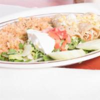 Enchiladas Suizas · Three chicken enchiladas topped with green sauce, queso fresco and corn. Served with rice, r...