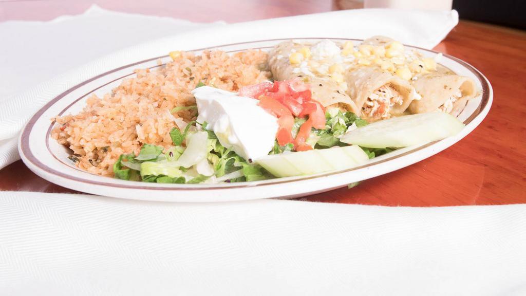 Enchiladas Suizas · Three chicken enchiladas topped with green sauce, queso fresco and corn. Served with rice, romaine mix, sour cream and tomatoes.