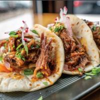 Korean Short Rib Tacos · braised Short Rib glazed with Korean miso sauce
over kimchi in a flour tortilla, and topped ...