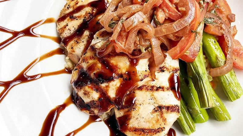 Mediterranean Chicken · flavorful grilled chicken breasts over rice pilaf and asparagus, served with roma tomatoes, balsamic caramelized onions and a balsamic reduction.