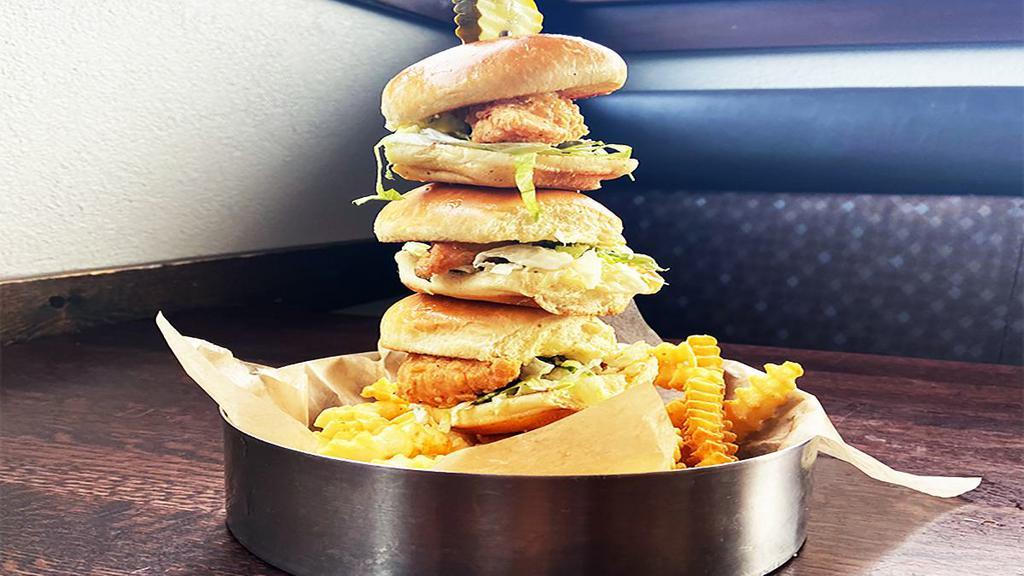 Chicken Tender Slider Tower · Crispy buttermilk-fried chicken tenders on brioche slider buns with our homemade lemon aioli, shredded lettuce, and sliced pickles. Piled high and served over french fries.