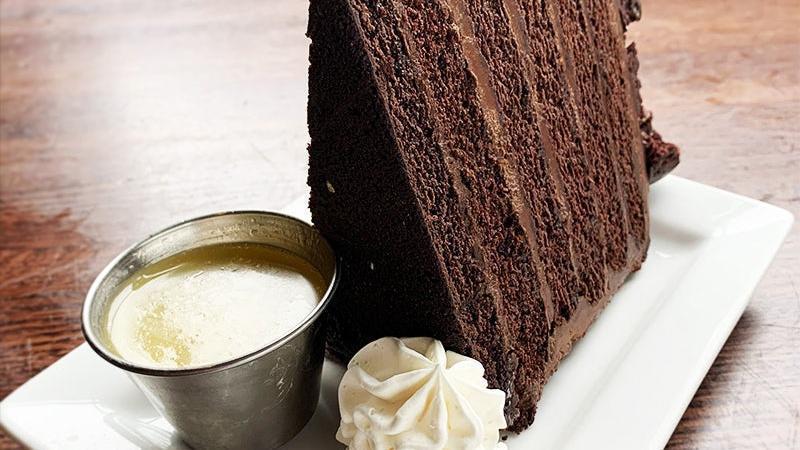 Chocolate Cake · Decadent chocolate layer cake with bourbon caramel sauce and a touch of whipped cream.