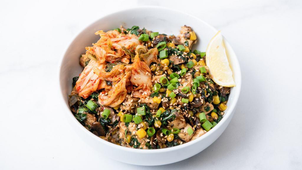 Sweet Chicken Kimchi · Marinated chicken sauteed with KBBQ sauce, vegan kimchi, roasted corn, peppers & onions, citrus-marinated kale, green onions, and sesame seeds. Served with a lemon wedge and a base of your choice. (Gluten-free)