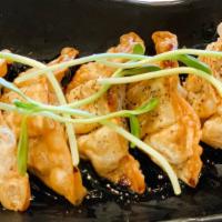 Truffle Chicken Gyoza · Truffle oil, house-made tempura sauce, and organic micro greens.