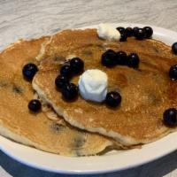 Blueberry Pancakes · Three large buttermilk pancakes stuffed with blueberries.