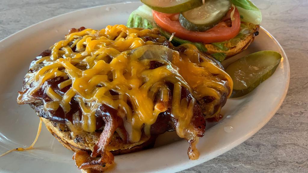 Cowboy Burger · Topped with bacon, grilled onion, cheddar cheese and our sweet BBQ sauce.