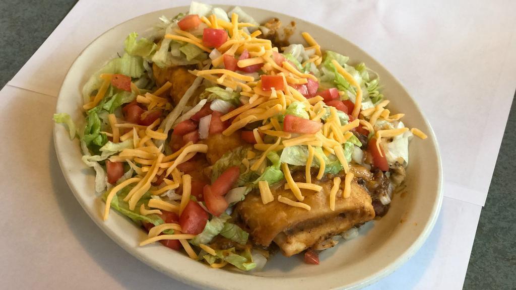 Saucy Burrito · Smothered with chili, shredded lettuce, onions, tomatoes and cheddar cheese.