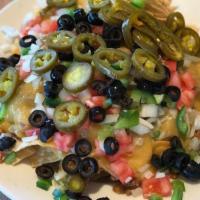 Super Nachos With Nacho Sauce · Tortilla chips topped with seasoned ground beef, .melted cheese, onions, green peppers, jala...