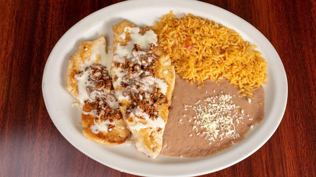 Chori Pollo · Grilled chicken breast. Topped with chorizo mexican sausage and cheese sauce. Served with rice, beans and tortillas.