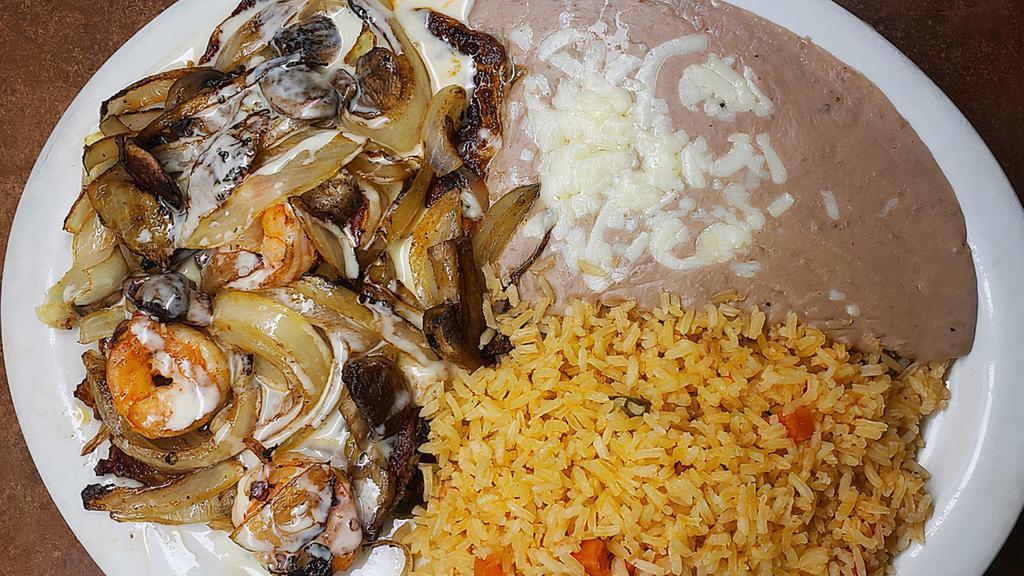 Pollo Marino · Seasoned chicken breast and grilled shrimp topped with mushrooms, onions, and cheese sauce. Served with rice and beans.