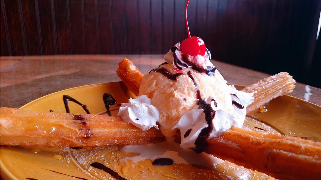 Churros · Deep-fried churros (stuffed with custard) topped with vanilla ice cream, honey, chocolate syrup and whipped cream! A perfect ending to an authentic Mexican meal!