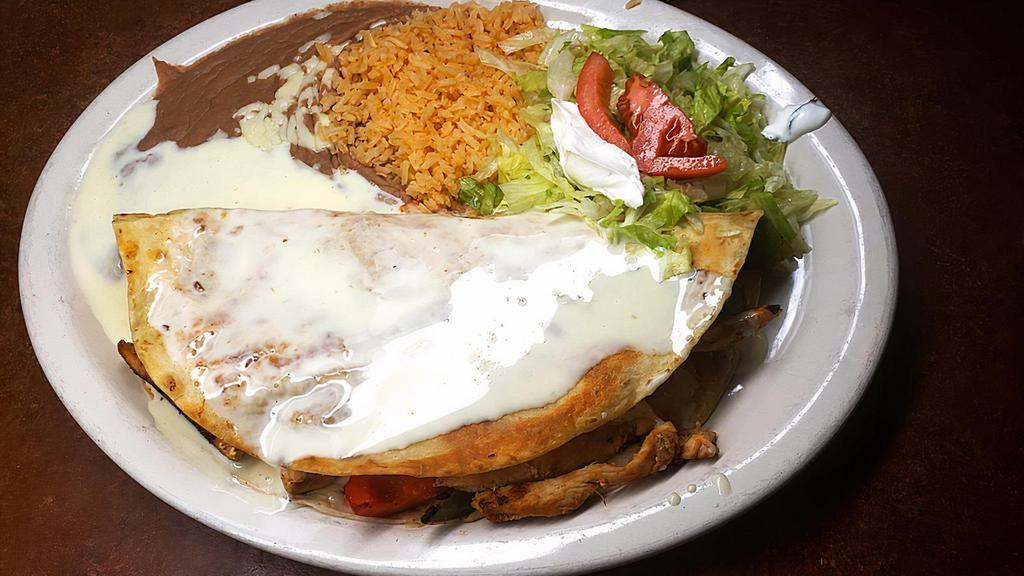 Fajita Quesadilla · A flour tortilla stuffed with grilled steak or chicken stir-fried with onions, tomatoes and bell peppers. Topped with our red burrito sauce and cheese sauce. Served with rice and guacamole sour cream salad.