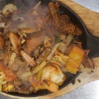 Mi Tradicion Fajitas · A combination of grilled  shrimp, steak, chicken, chorizo and carnitas, peppers, onions, and...