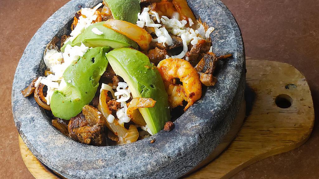 Molcajete Fajitas · Steak, Shrimp, & Chorizo. A combination of grilled  shrimp, steak and chorizo, onions, and tomatoes. Served with rice, refried beans, lettuce, sour cream, guacamole and tortillas