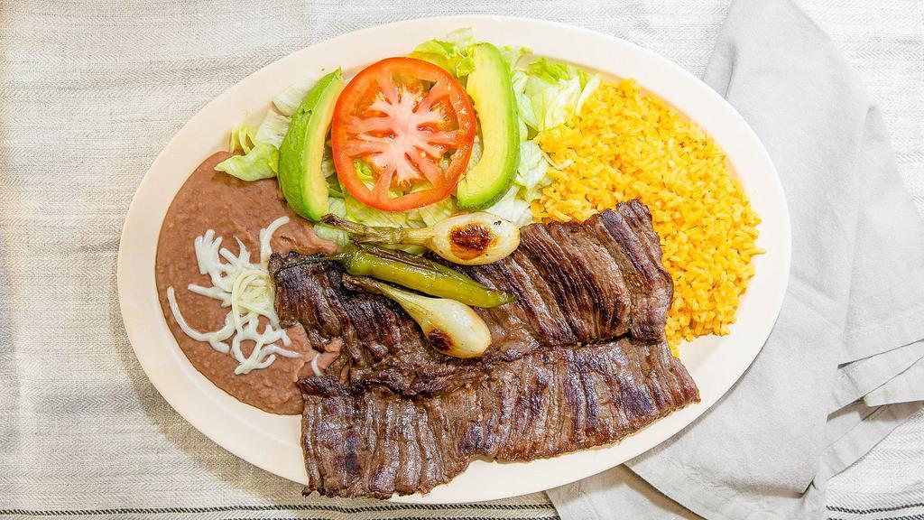 Carne Asada · Grilled skirt steak served with with cactus, grilled onions, and peppers. Served with rice and beans.