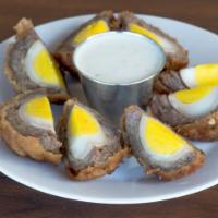 Scotch Eggs · Two hard-boiled eggs wrapped in sausage, breaded, then deep-fried and served with creamy gar...