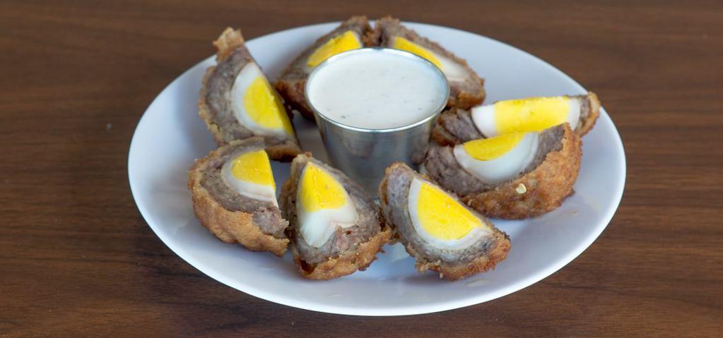 Scotch Eggs · Two hard-boiled eggs wrapped in sausage, breaded, then deep-fried and served with creamy garlic ranch dip.
