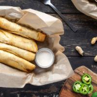 Chicken Flautas · Hand-rolled flour tortillas stuffed with grilled chicken, cheese, refried beans, and jalapeñ...
