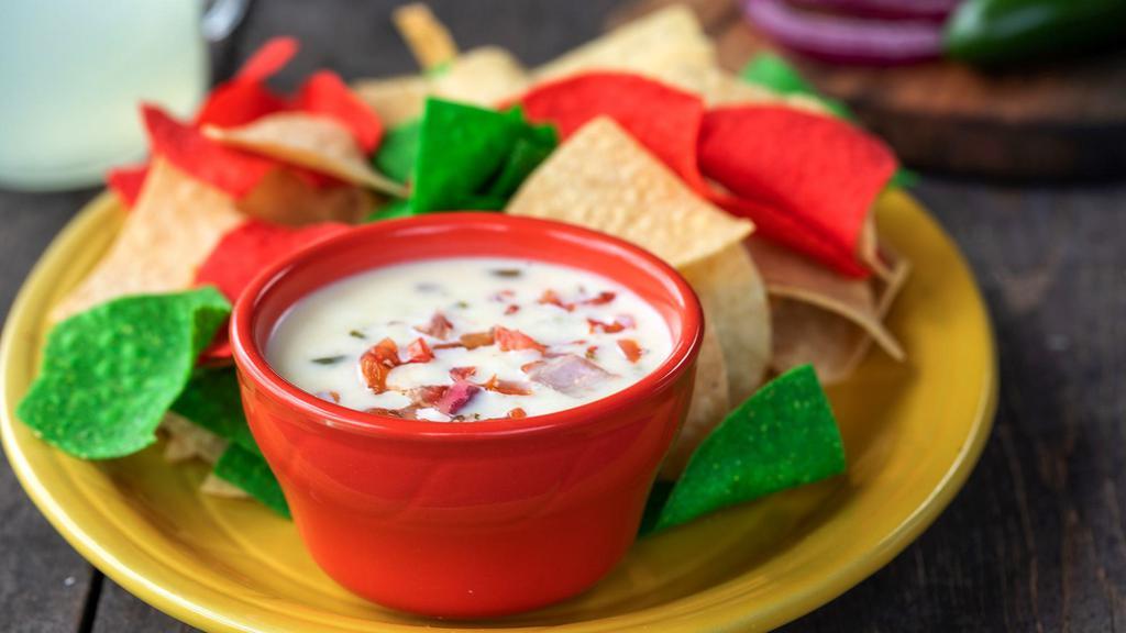 Loaded Queso Blanco · Our creamy white cheese dip with a hint of jalapeños, pico de gallo and beef served with warm tortilla chips.