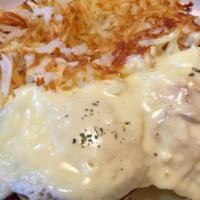 Eggs Commodore · Two basted eggs with sausage on an English muffin, topped with hollandaise sauce and served ...