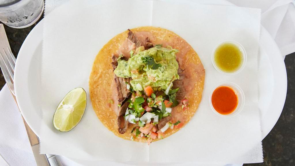 Cecina Steak · Handcrafted specialty taco. Cecina steak is handcut and cured inhouse and topped with pico de gallo, guacamole served on a tortilla with a slab of homemade beans.