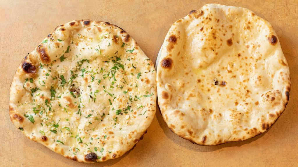 Garlic Naan · Plain bread baked in a clay oven sprinkled with garlic and cilantro.