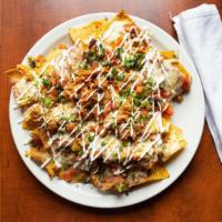 Nachos · Crispy chips topped with refried beans, chicken tinga, melted cheese, pico de gallo and sour...