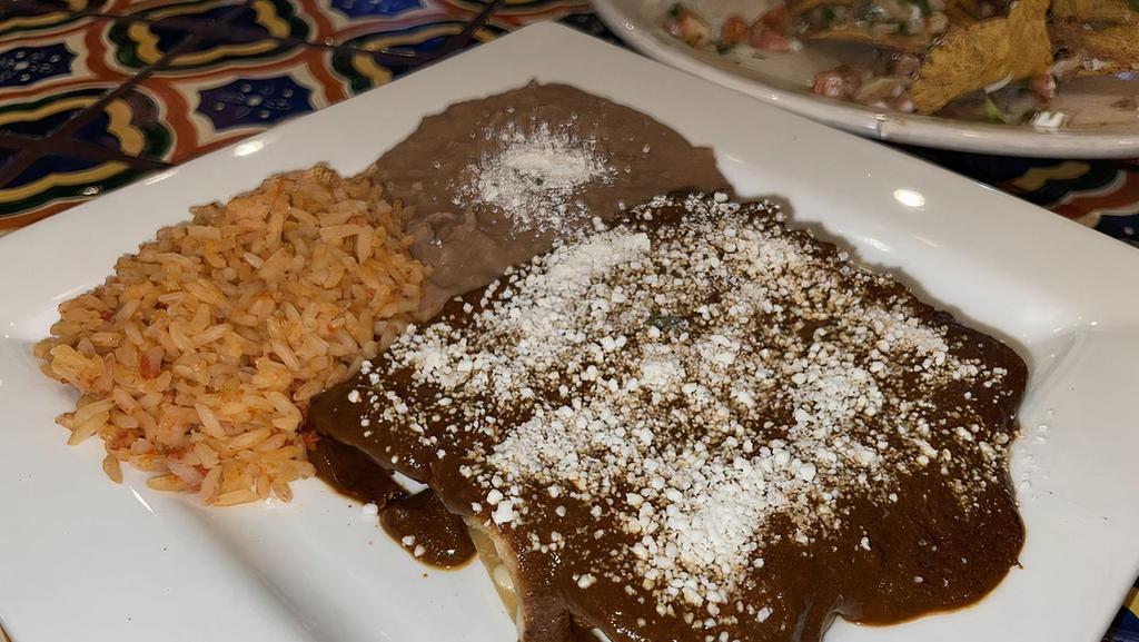 Enchiladas De Mole · Three enchiladas filled with cheese, chicken tinga or beef topped with mole and cotija cheese, side of rice and beans. Add steak for an additional charge.