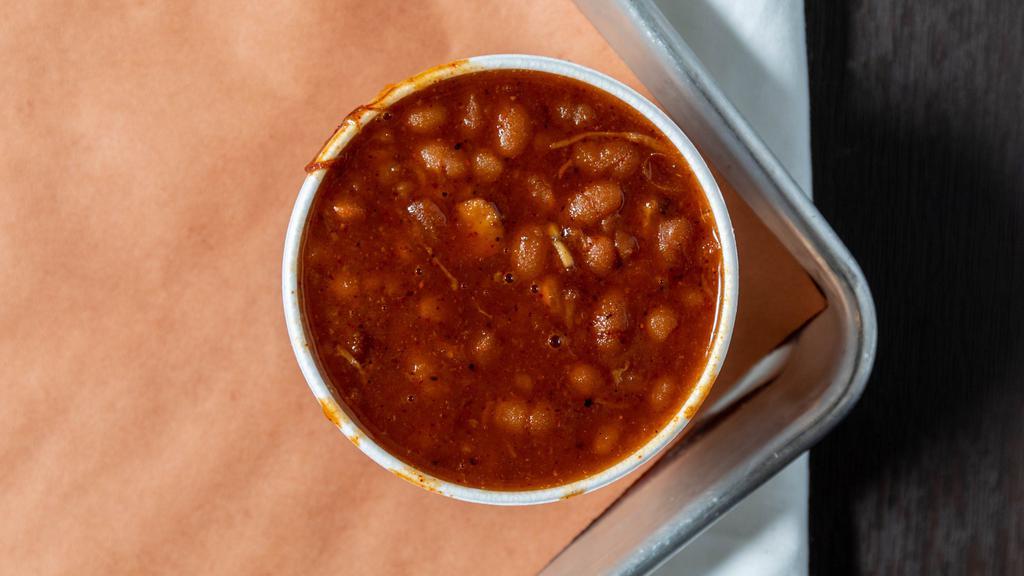 Smoked Baked Beans · A variety of beans jazzed up with our in house ingredients, then loaded with onions, brisket and pork (cause why not?).
