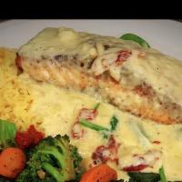 Salmon Al-Bianca · Grilled Atlantic salmon topped with house lemon cream sauce and sun dried tomatoes, served o...