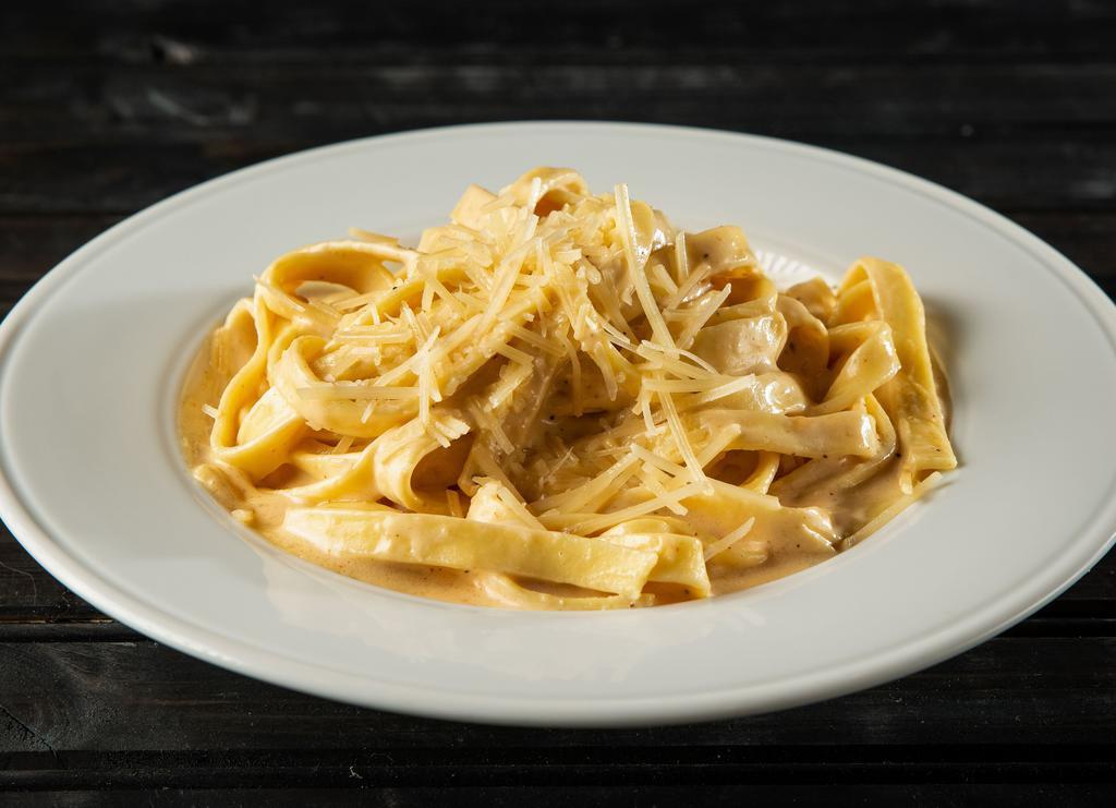 Fettuccine Alfredo · Fettuccine noodles tossed in our alfredo sauce and topped with parmesan cheese.