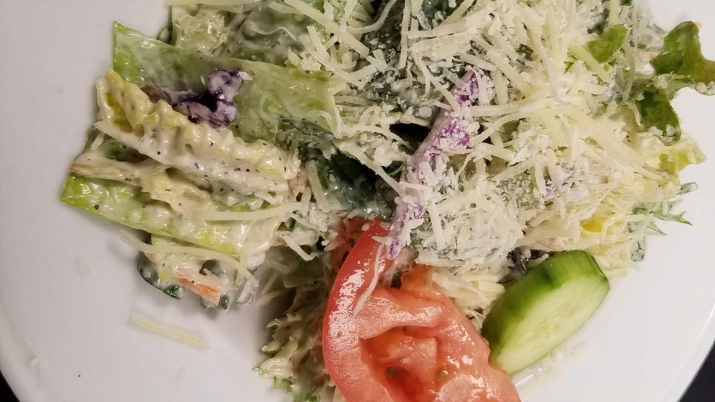 Side House Salad · Artisan greens, Romaine, and iceberg tossed in our signature creamy Parmesan vinaigrette dressing, topped with Roma tomato, cucumber, and shredded Parmesan cheese. Substitute any of our house made dressings: pesto ranch, Caesar, balsamic vinaigrette, or bleu cheese. All side salads are served with dressing on the side.