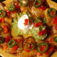 Grande Nachos · Fajita chicken, seasoned ground beef or layered onto refried bean tostadas, topped with mixe...