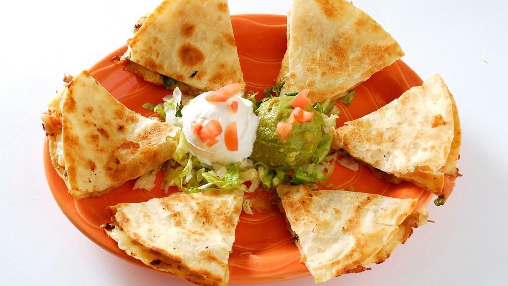 Shrimp Quesadillas · Pepper jack cheese, fresh-grilled shrimp, sautéed tomatoes, poblano peppers and onions in a grilled flour tortilla. Served with sour cream and guacamole.