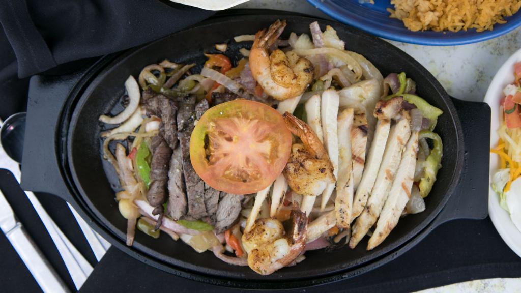 Fajita Trio · A combination of shrimp, chicken and steak fajitas served to you on a sizzling platter with grilled bell peppers and onions.
